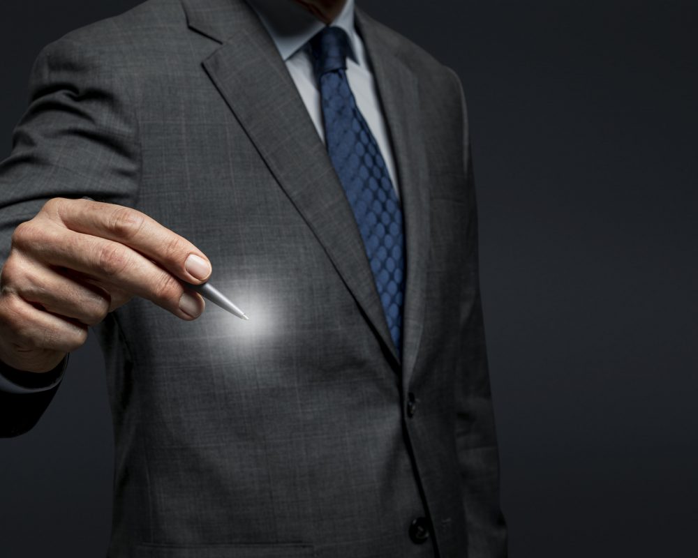 Businessman using a pen and signing on an invisible screen Businessman using a pen and signing on an invisible screen